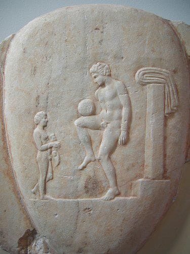 A Greek figure with a ball. Games involving kicking a ball are ancient and widespread, and none of them is the direct ancestor of the modern sport.