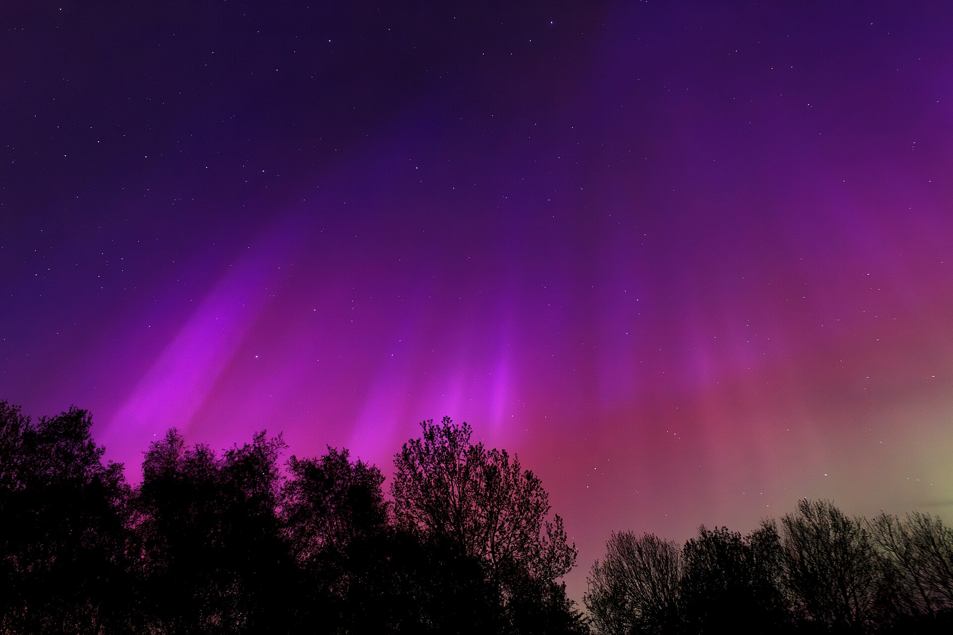 The aurora over Sweden, glowing green from oxygen high in the atmosphere.