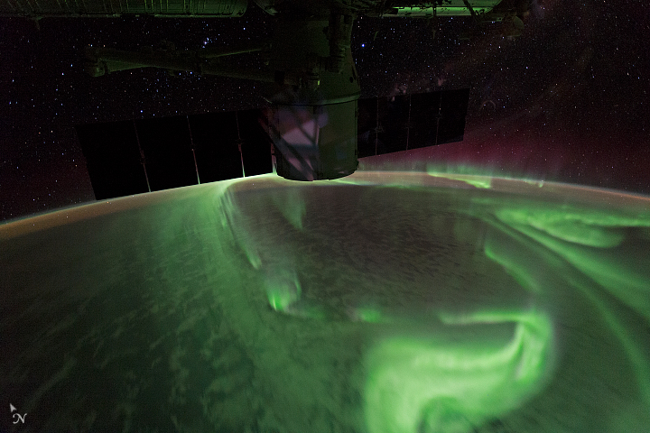 An astronaut's view of the aurora from orbit, glowing in a ring around the pole.