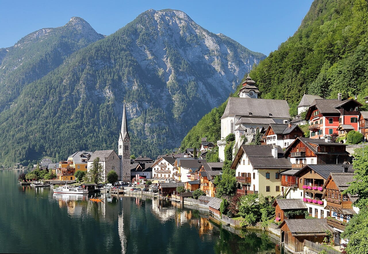 The village of Hallstatt, reflected in its Alpine lake amid steep mountains, one of the most photographed places in Austria. Scenery like this, of peaks, valleys, and lakes, draws visitors and skiers from around the world.