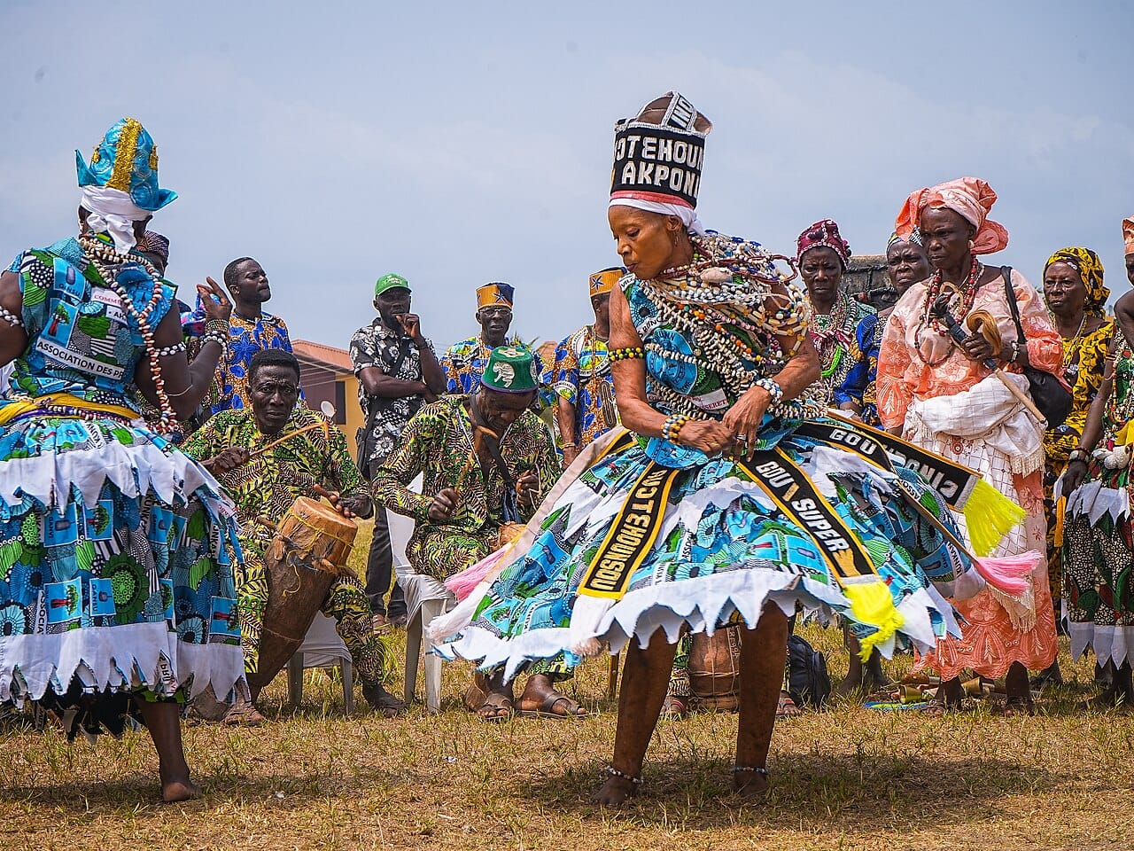 Vodunsi, initiates of the Vodun religion, in ceremonial dress. Vodun originated on this coast and travelled with enslaved people to become Haitian Vodou, Cuban Santeria, and Brazilian Candomble; Benin has marked it with a national holiday since 1996.