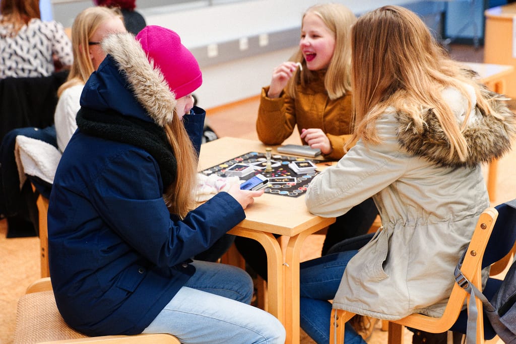 People playing in a public library. Board games are social objects, and much of their function is providing structured occasion for people to spend time together.