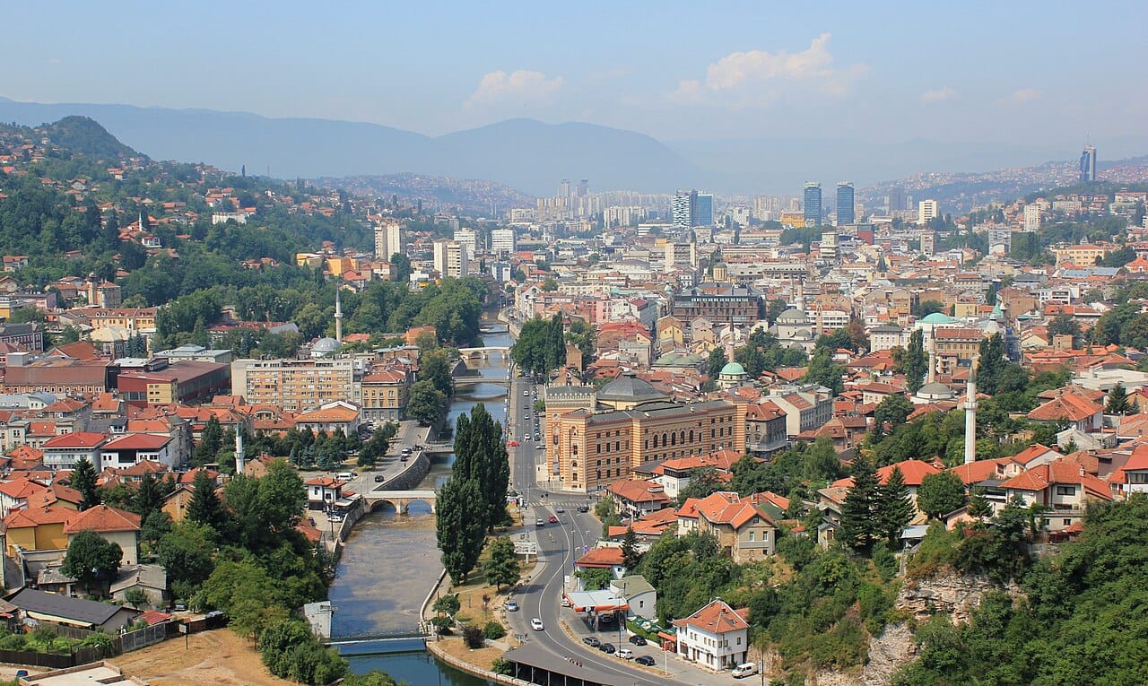 A panorama of Sarajevo, the capital of Bosnia and Herzegovina, set in a valley ringed by mountains. Long celebrated for the meeting of its mosques, churches, and synagogues, the city endured a savage siege in the 1990s and remains the symbolic heart of the nation.