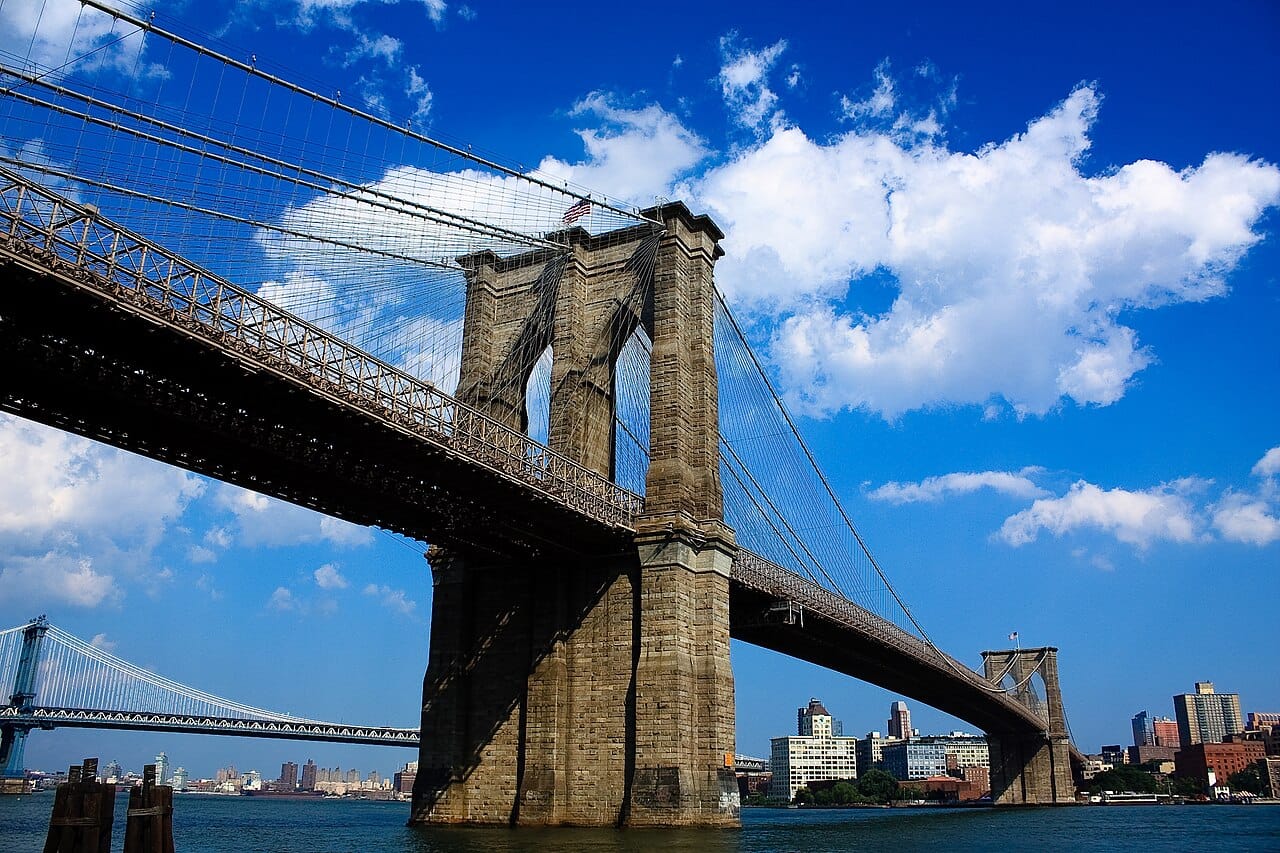 The Brooklyn Bridge, completed in 1883. It combined suspension cables with diagonal stays and was the first to use steel wire, and it remains in service.