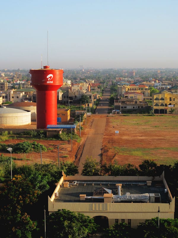 The skyline of Ouagadougou, the capital and largest city of Burkina Faso. Home to the FESPACO film festival, it is the political and cultural heart of the nation, though violence in the countryside has driven many of the displaced into its edges.