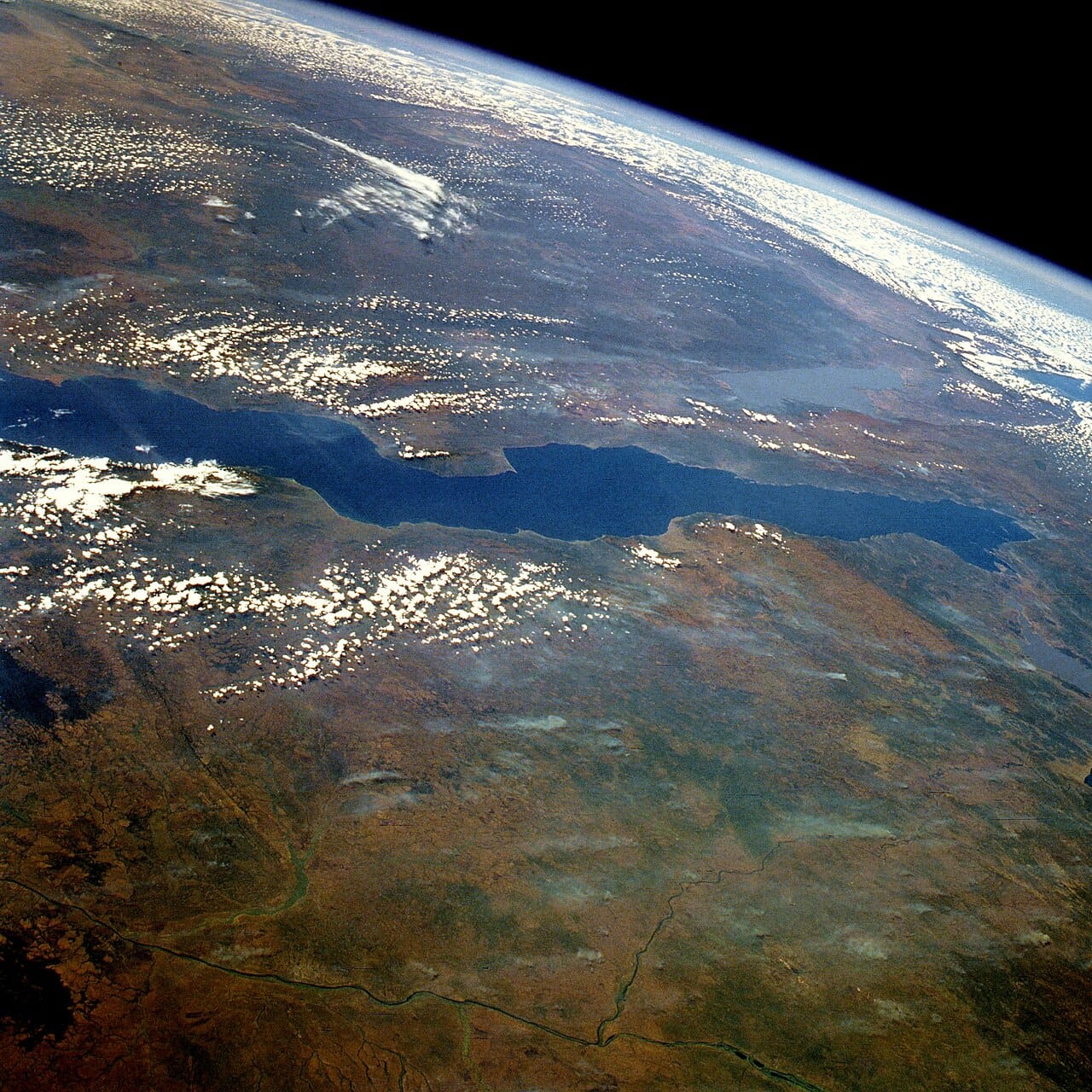 Lake Tanganyika from orbit. The second deepest and second oldest lake in the world, it forms Burundi's western border, supplies much of the country's protein, and holds a remarkable radiation of endemic fish.
