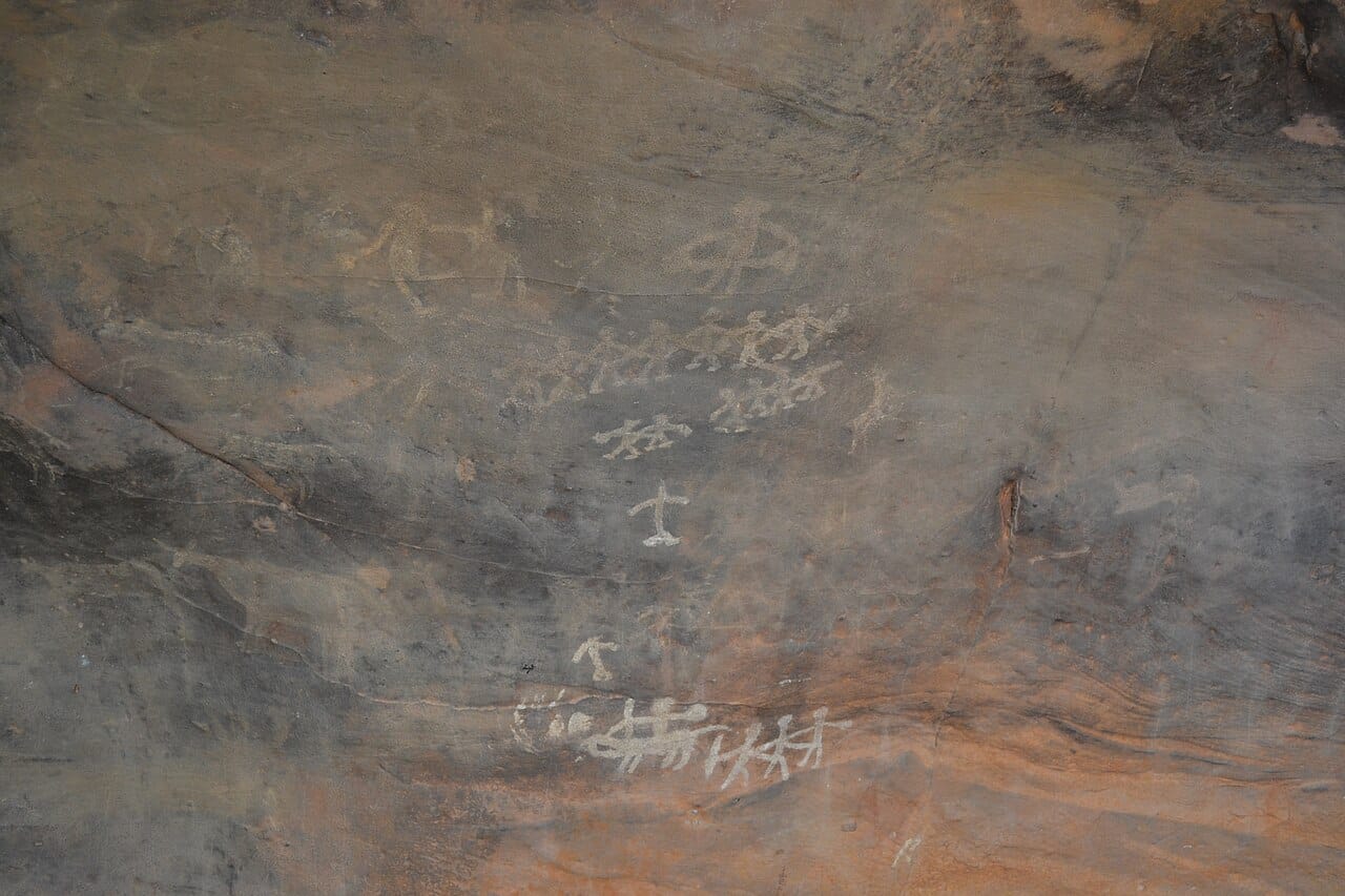 A prehistoric rock painting showing figures in what appears to be a dance. Depictions are the principal early evidence, and interpreting them is unavoidably uncertain.