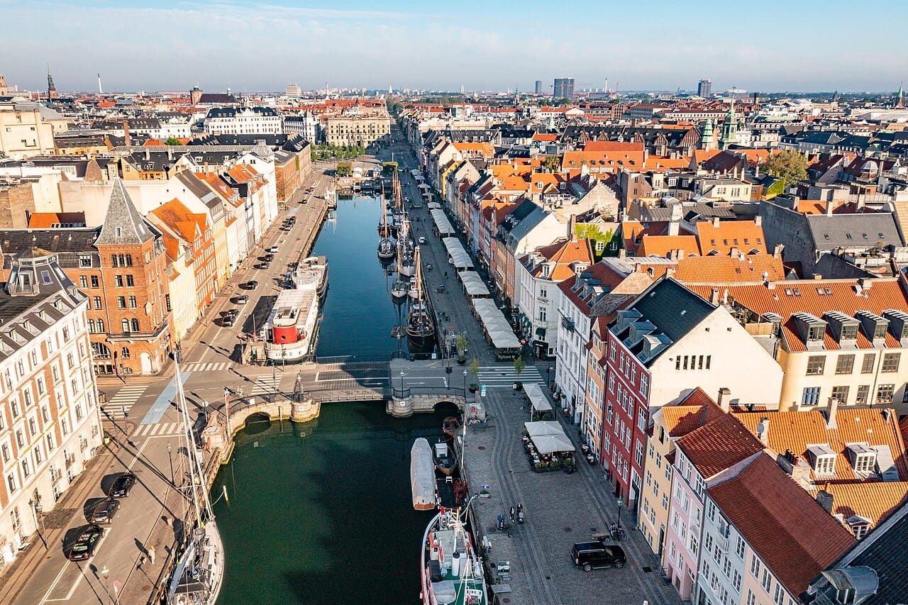The old harbour of Nyhavn in Copenhagen, lined with brightly painted seventeenth-century houses. Once a rough sailors' quarter, it is now the picturesque emblem of a capital famous for its design, cycling, and quality of life.