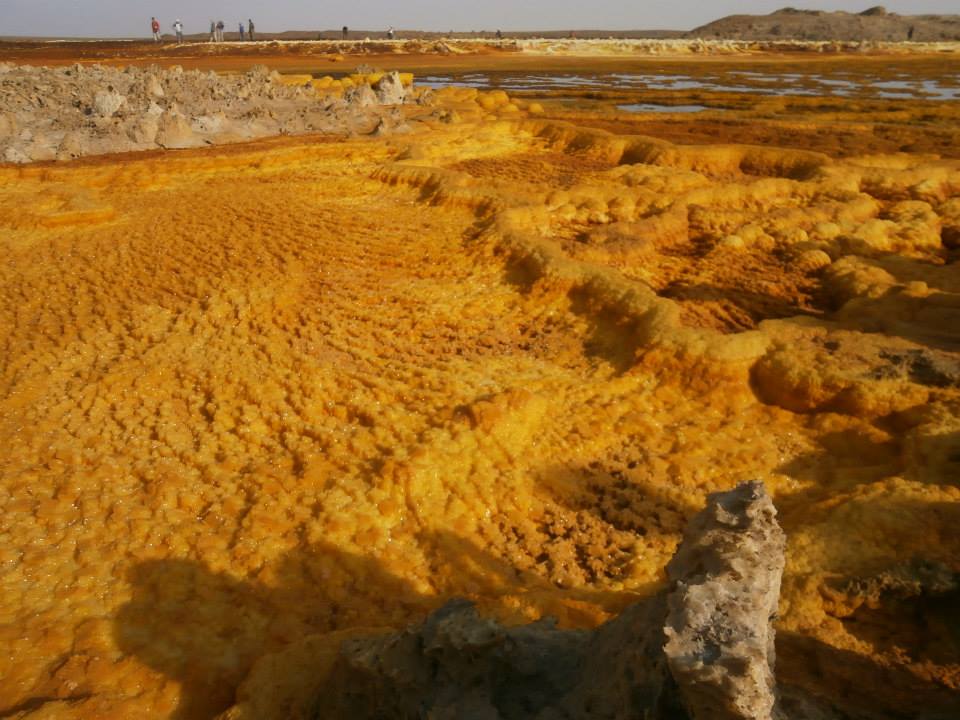 The Dallol area of the Danakil Depression, where salt, sulphur, and potash deposits colour the ground. The depression is among the hottest inhabited places on Earth and lies where three tectonic plates are pulling apart.