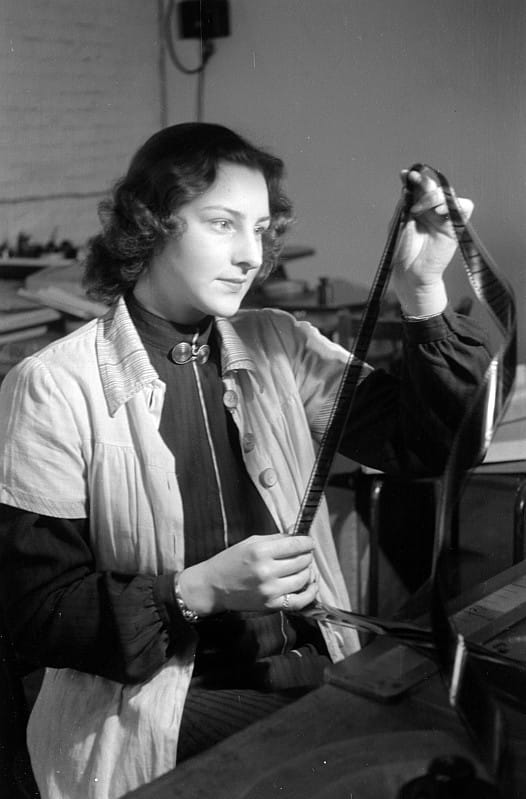 Film being cut and joined. Editing was physical for most of the medium's history, and the vocabulary still reflects it.