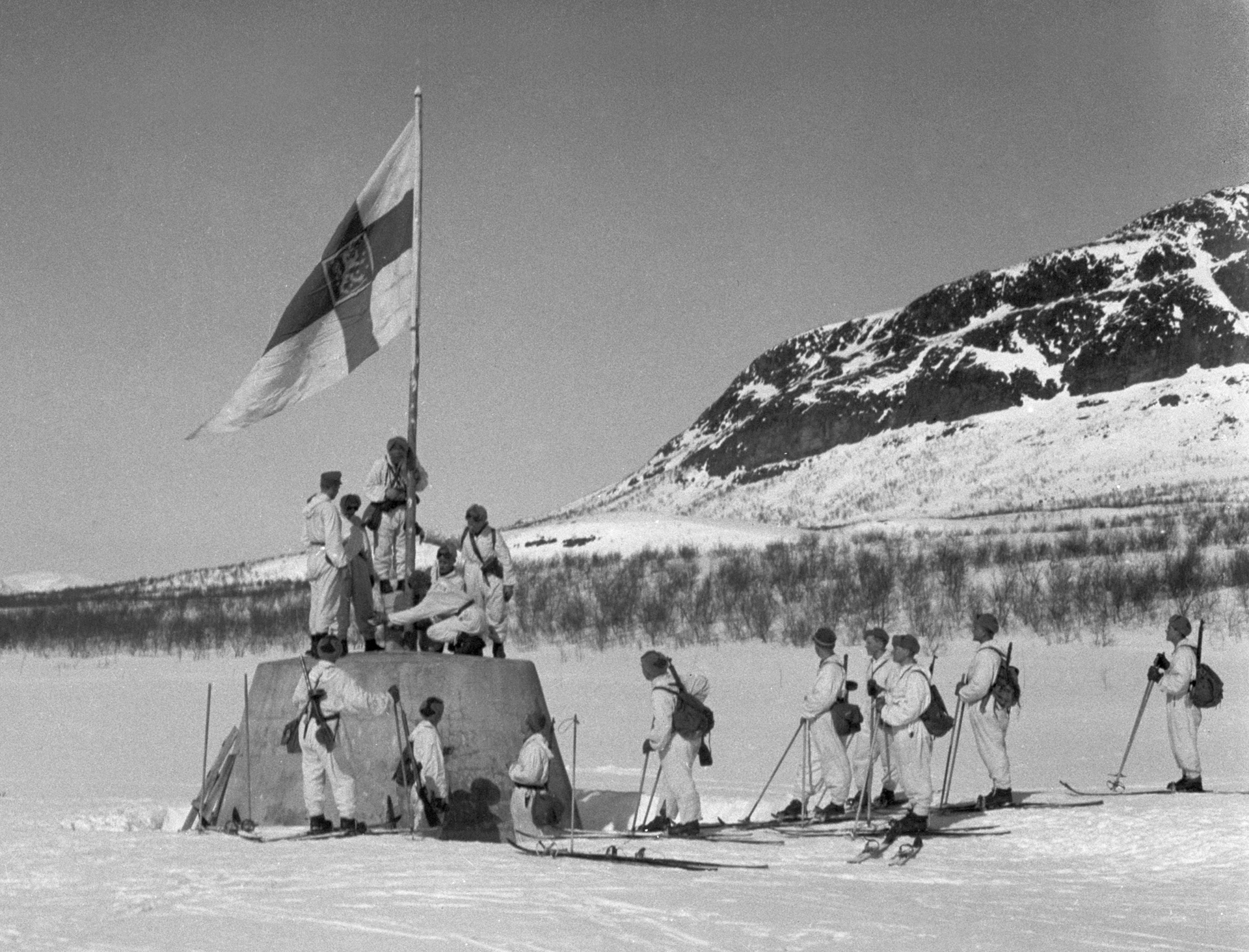 Finnish troops raise the flag at the three-country cairn marking the meeting of Finland, Sweden, and Norway. Finland fought hard to preserve its independence and borders through the Second World War against the Soviet Union.
