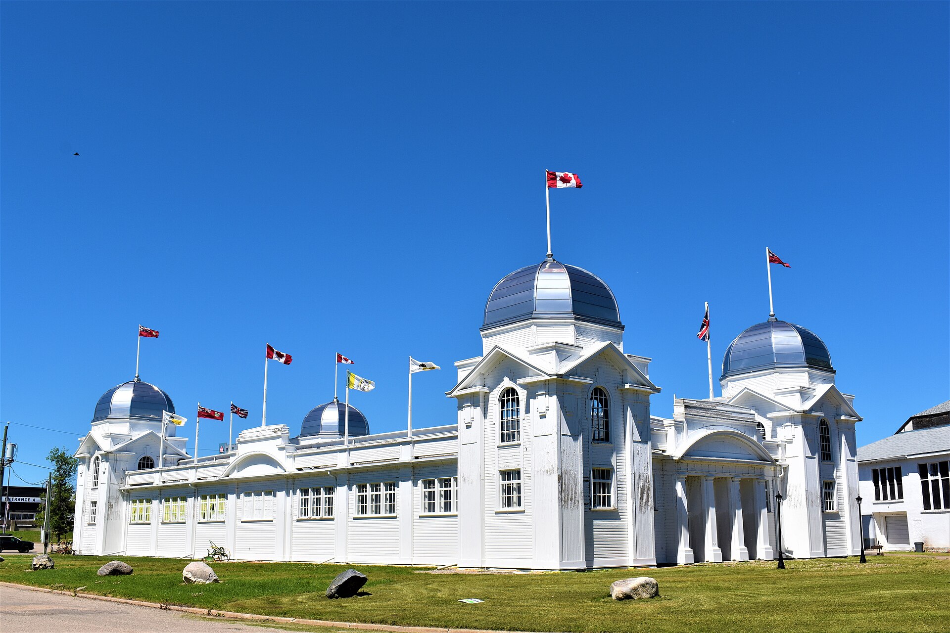 A view of the Dominion Exhibition Display Building II with the flags blowing in the wind. Taken from the south east of the building. Credit: Words in the Wind (CC BY-SA 4.0).