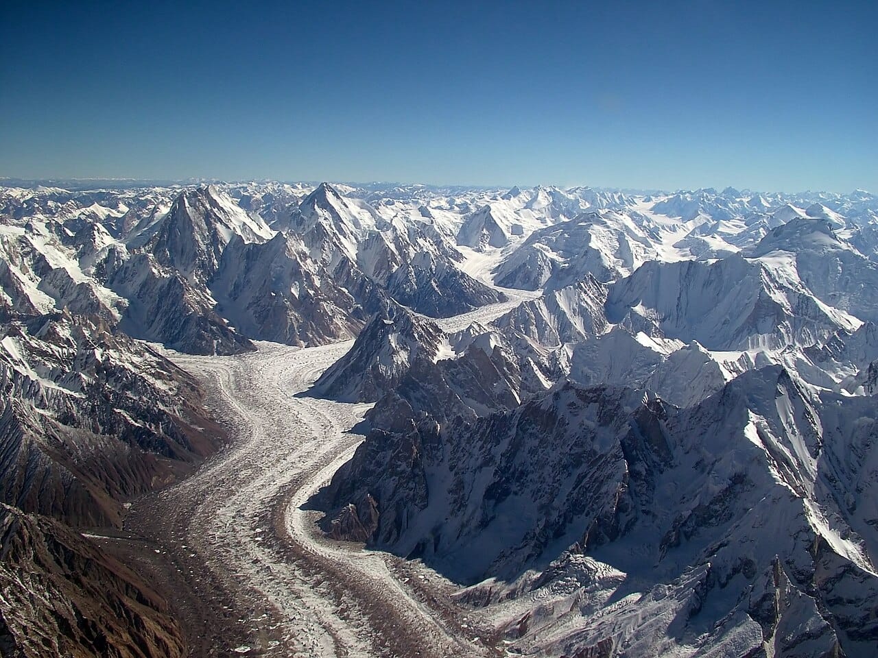The Baltoro glacier from the air. The dark stripes are moraines, bands of rock debris carried on and within the ice, which trace the merging of tributary glaciers.