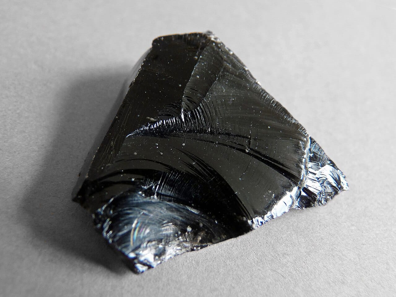 Obsidian, volcanic glass. Rapid cooling of molten rock produces the same disordered structure that manufactured glass has, and it was worked into tools long before glass was made.