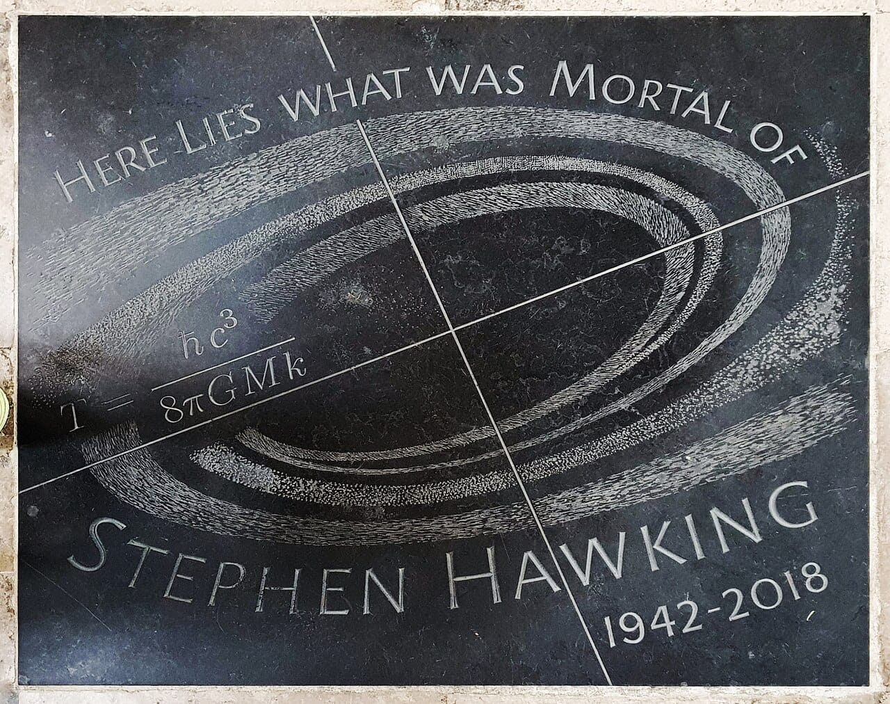Hawking's entropy formula on his memorial stone. That a black hole's entropy scales with its surface area rather than its volume is the observation the holographic principle generalises.