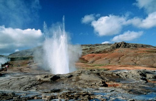 A geysir erupting in a column of boiling water and steam. Iceland sits on the volcanic Mid-Atlantic Ridge, and it is from this land that the very word geyser comes; the same heat warms the nation's homes and swimming pools.