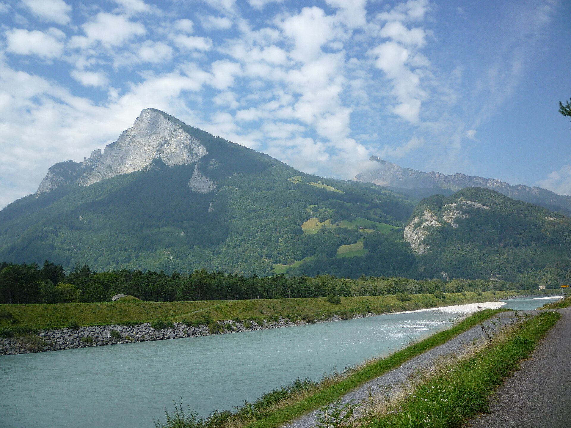 The Rhine near Balzers with the Gonzen beyond. The river forms the entire Swiss border, and the straightening and embanking of its floodplain in the nineteenth and twentieth centuries made the valley floor usable for the towns and industry that sit there now.