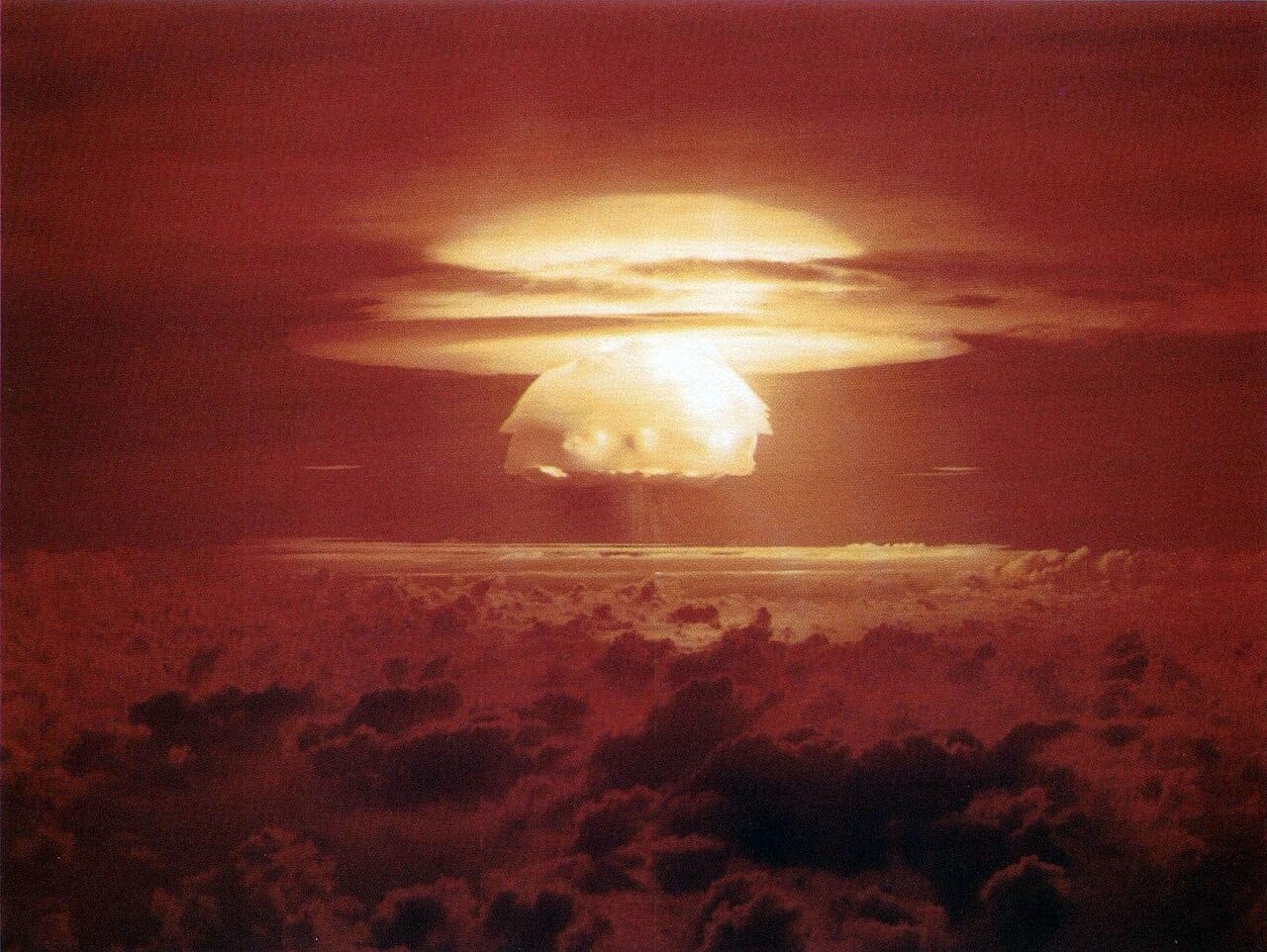The mushroom cloud of the Castle Bravo nuclear test at Bikini Atoll in 1954, the most powerful weapon the United States ever detonated. Its fallout spread across inhabited atolls, beginning a legacy of displacement, illness, and unresolved dispute that still shapes the Marshall Islands.
