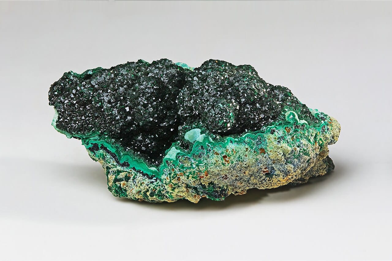 Malachite, a copper ore. Economically extractable deposits form where geological processes concentrated an element far above its average crustal abundance.