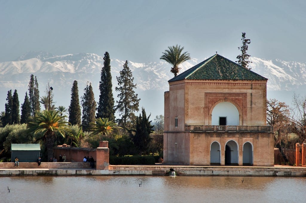 A pavilion and gardens in Marrakesh, with the Atlas Mountains beyond. One of Morocco's imperial cities, Marrakesh is a magnet for visitors, its palaces, gardens, and medina embodying the beauty of the country's urban heritage.