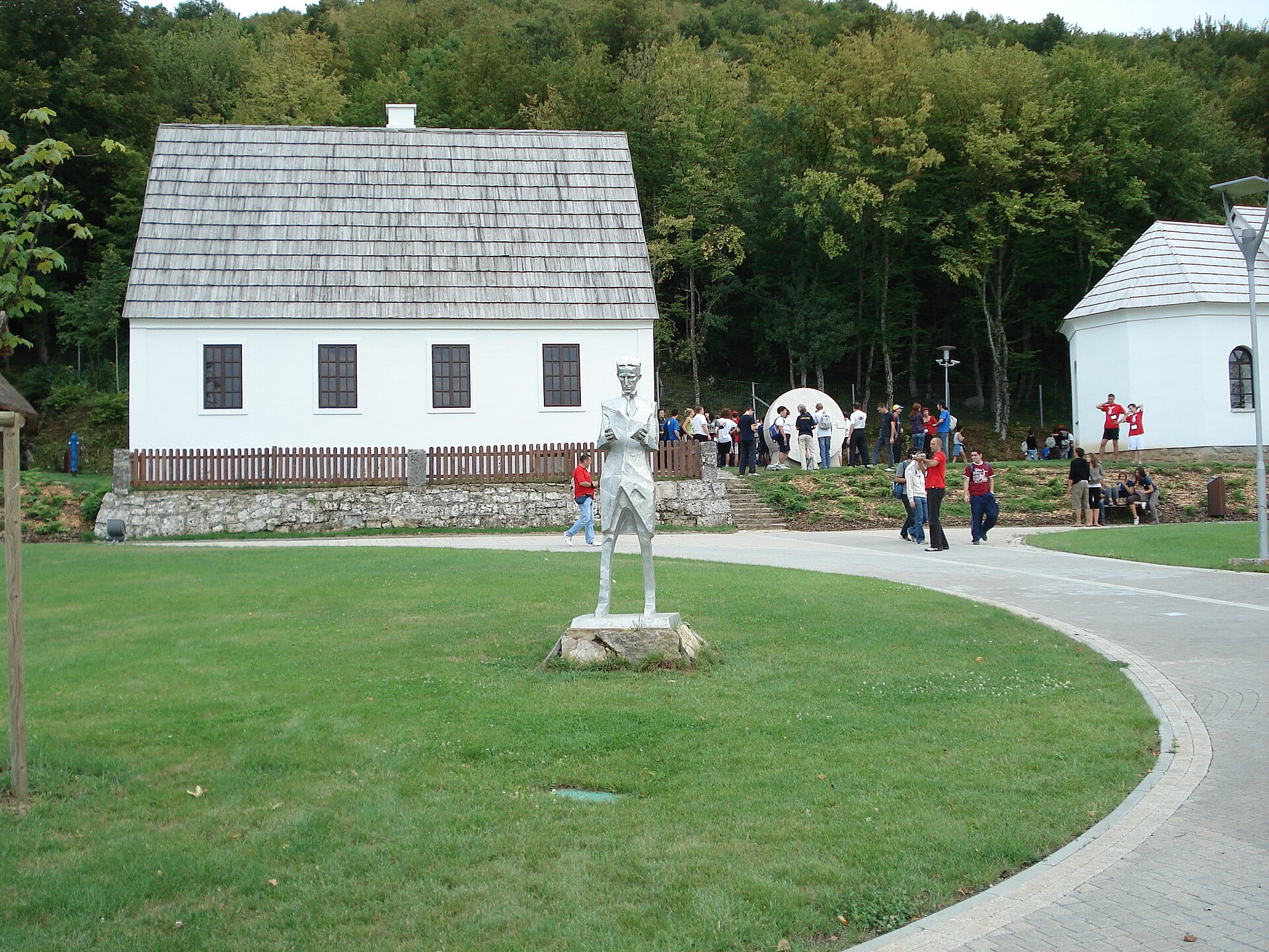 Tesla's reconstructed birth house and the church in Smiljan where his father served.