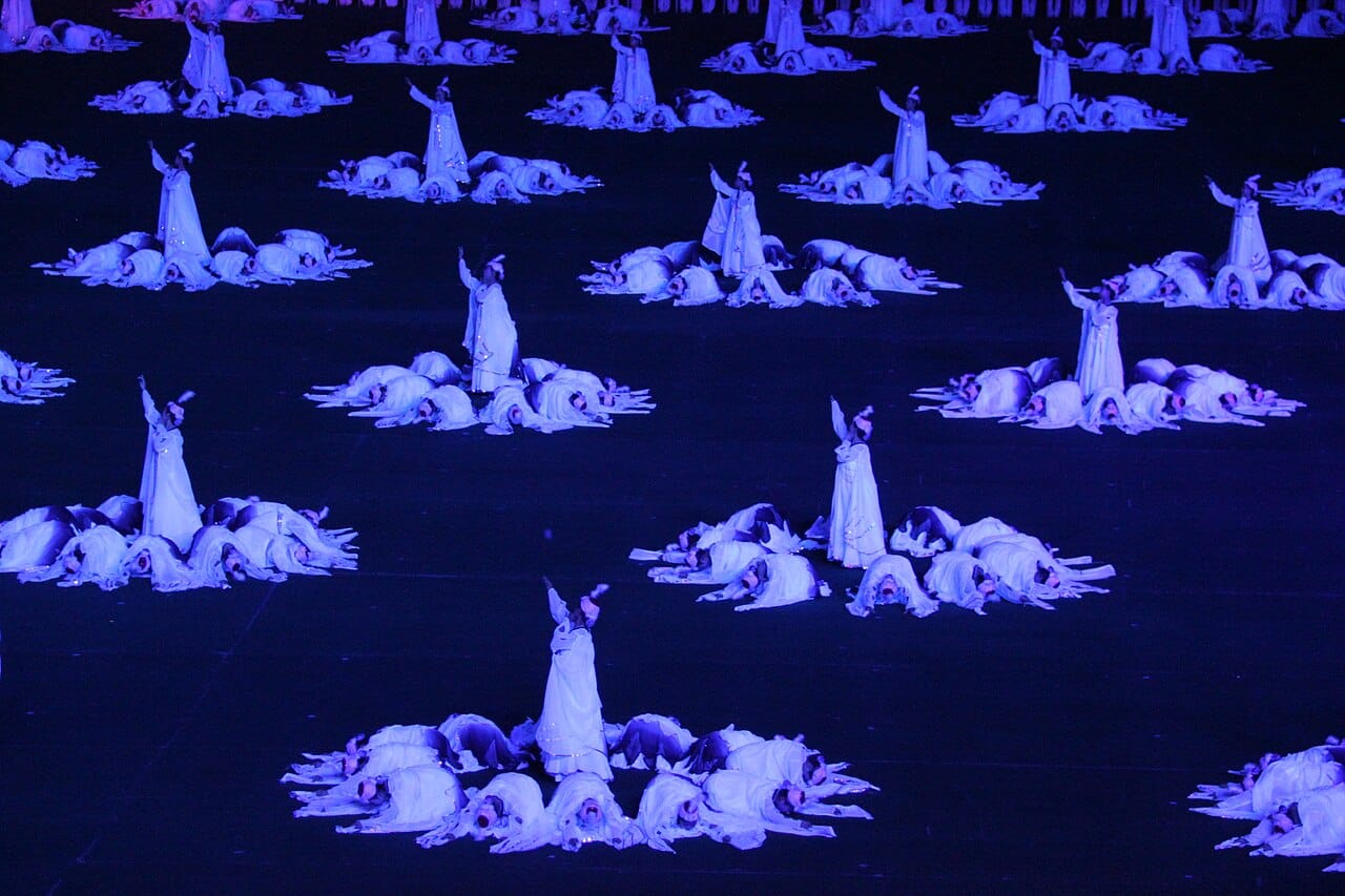 The Arirang mass games in Pyongyang. Tens of thousands of performers move in unison while a stand of schoolchildren holds up coloured cards to build vast shifting images, a spectacle requiring months of rehearsal.