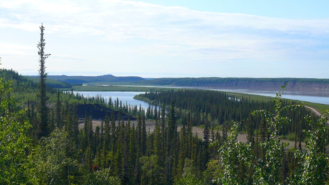 The Mackenzie River, the longest river system in Canada, winding north toward the Arctic Ocean. For centuries it has been a highway through the heart of the territory.