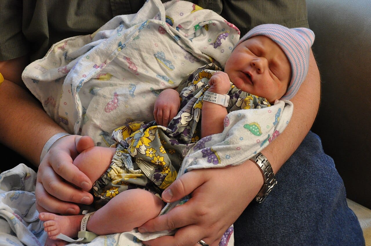 A human newborn. The helplessness of human infants relative to other primate newborns is the observation the hypothesis explains as birth occurring early to fit the pelvis.