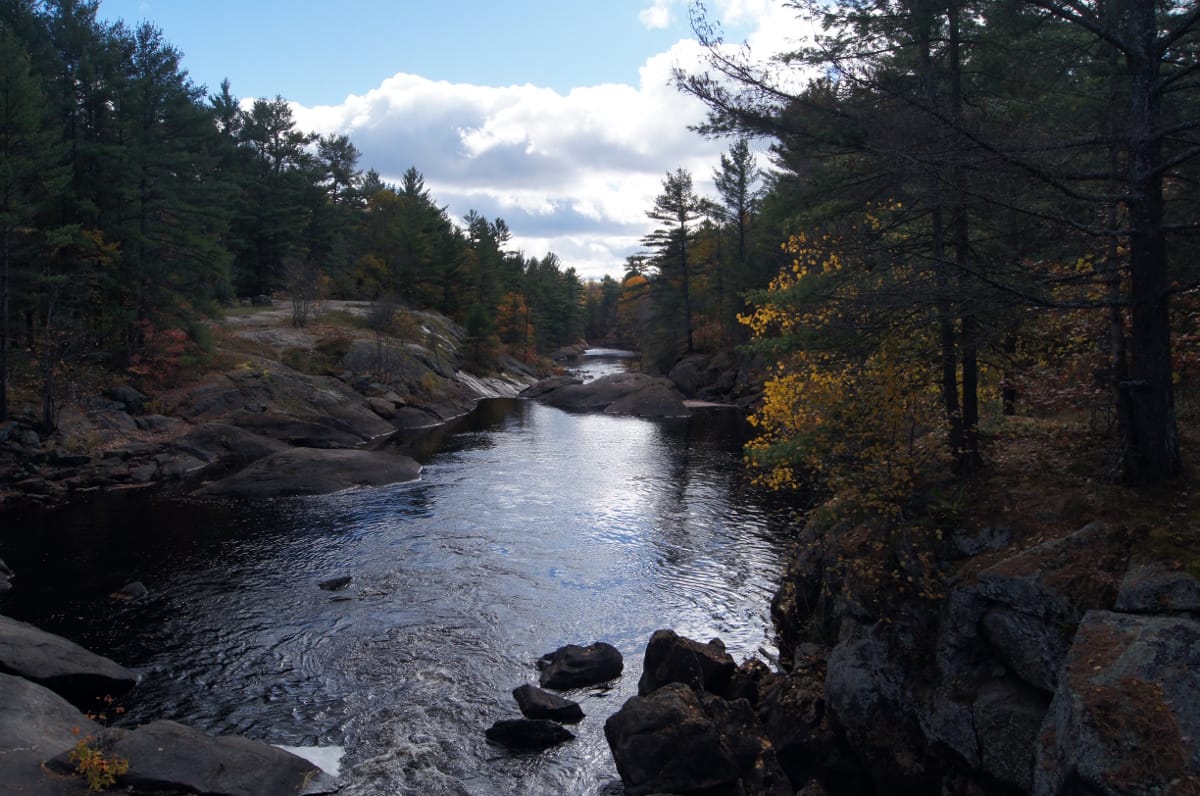 A river winding through the rock and forest of the Canadian Shield, which covers much of northern Ontario. This ancient landscape of lakes and woods stretches across the vast, thinly settled north of the province.