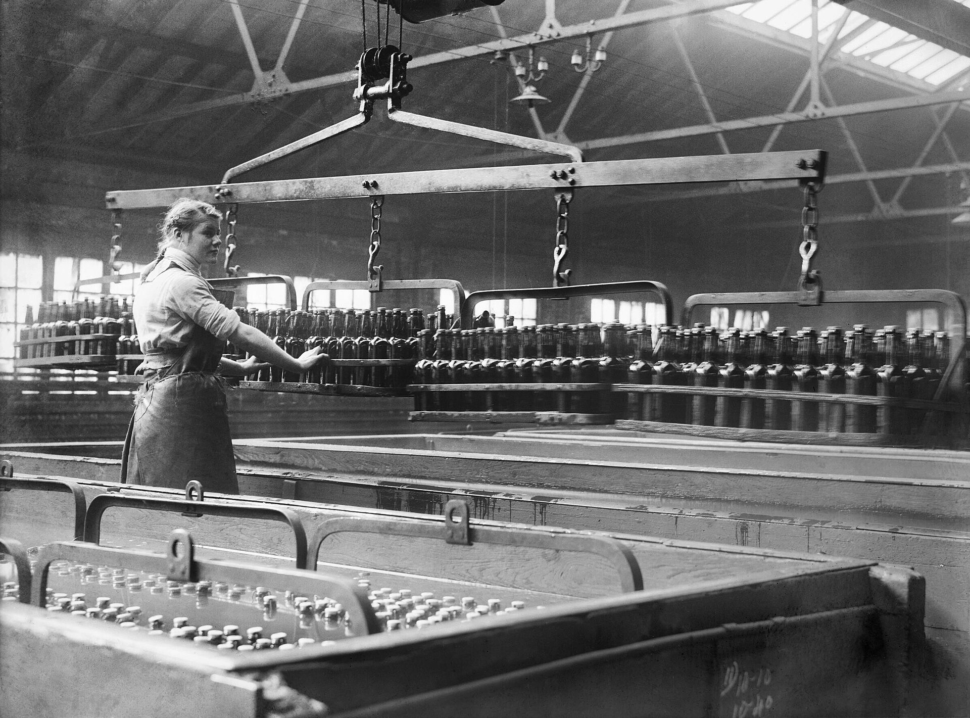 A worker tending a pasteurization tank at a brewery, an early use of Pasteur's method.