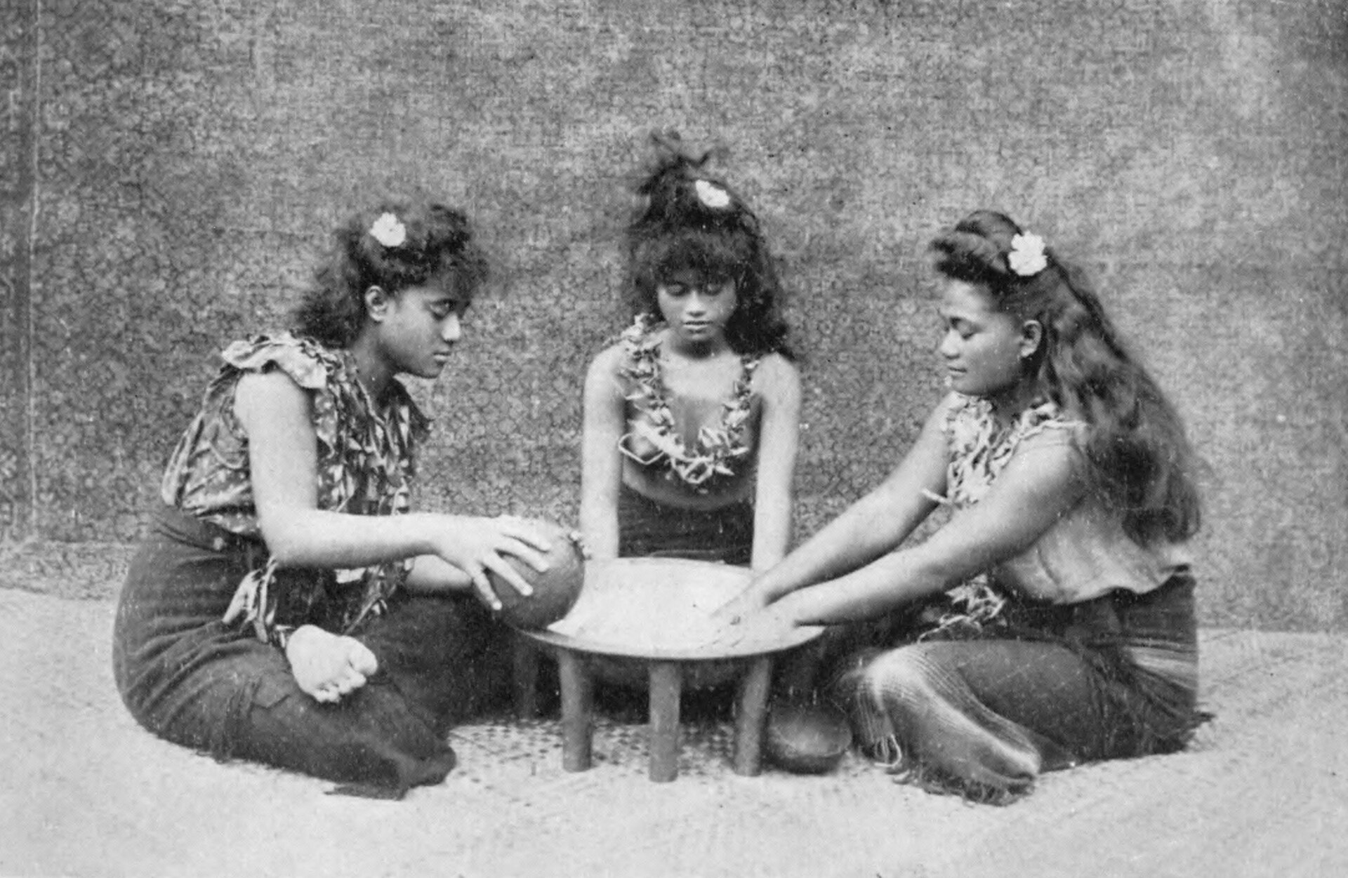 Young women preparing ava, the ceremonial drink also known as kava, in a photograph from 1909. The formal making and sharing of ava remains a central ritual of Samoan custom, marking welcomes, gatherings, and the bestowal of chiefly titles.