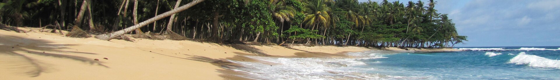 The beach at Praia Inhame in the south of São Tomé. Lush, green, and remote, straddling the equator in the Gulf of Guinea, the islands are ringed by tropical beaches and rich waters.