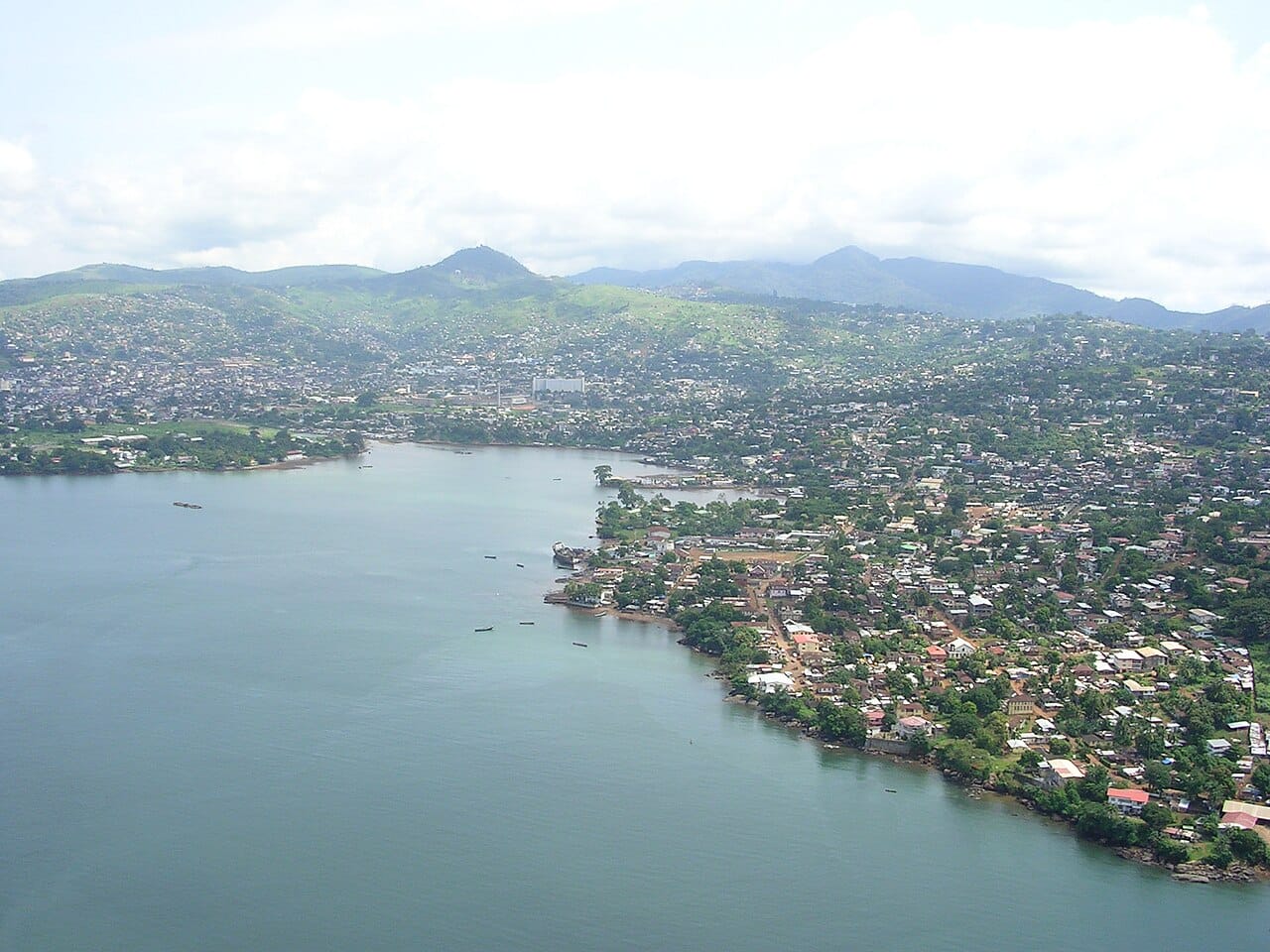 An aerial view of Freetown, the capital of Sierra Leone, spread along its mountainous peninsula beside one of the largest natural harbours in the world. Founded as a haven for freed slaves, it remains the heart of the nation.
