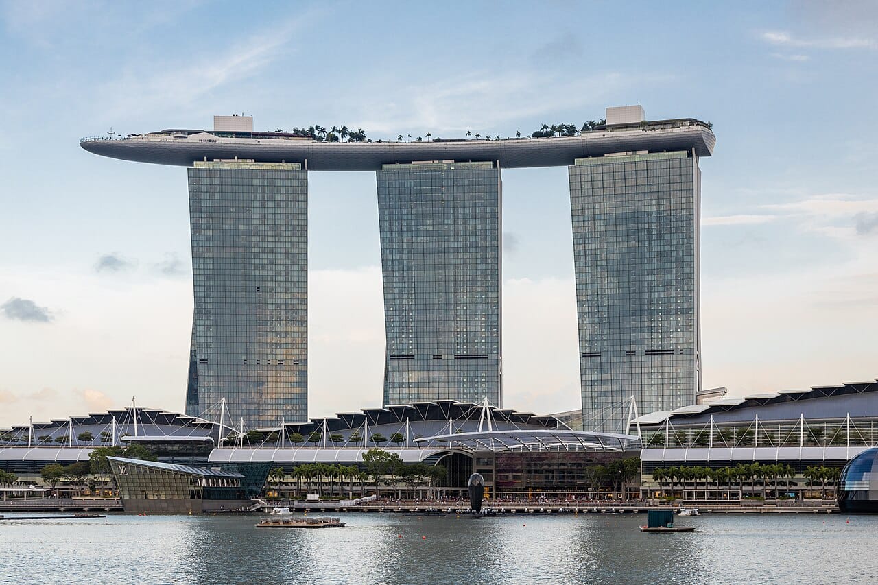 Marina Bay Sands, three towers joined by a boat-shaped sky park, opened in 2010 on reclaimed land. The building has become the visual shorthand for modern Singapore, and the integrated resort that contains it marked the country's contested decision to permit casinos.