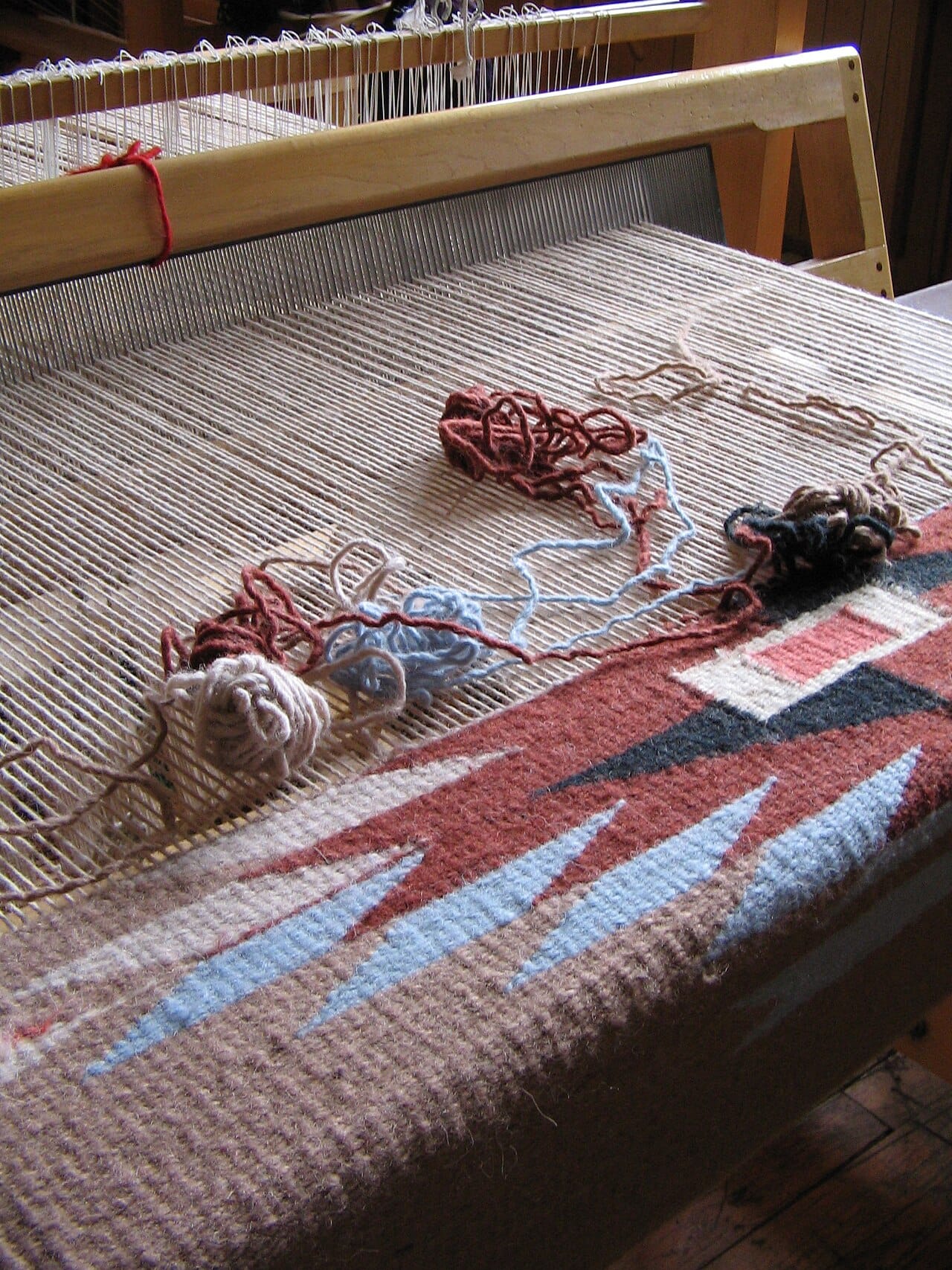 A warp being prepared on a loom. Weaving interlaces two sets of yarn at right angles, and setting up the warp is the slow part of the process.