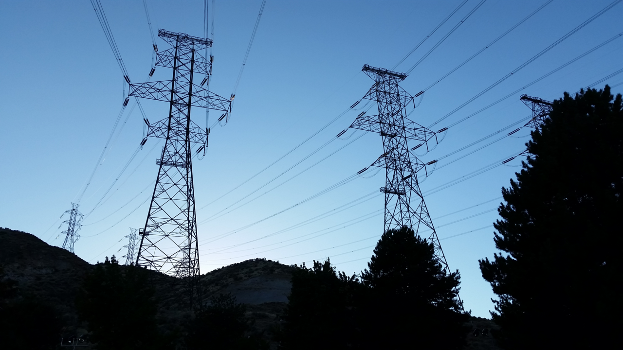 High voltage transmission lines. Raising voltage reduces current for the same power, and losses depend on the square of current, which is why long-distance transmission uses hundreds of kilovolts.