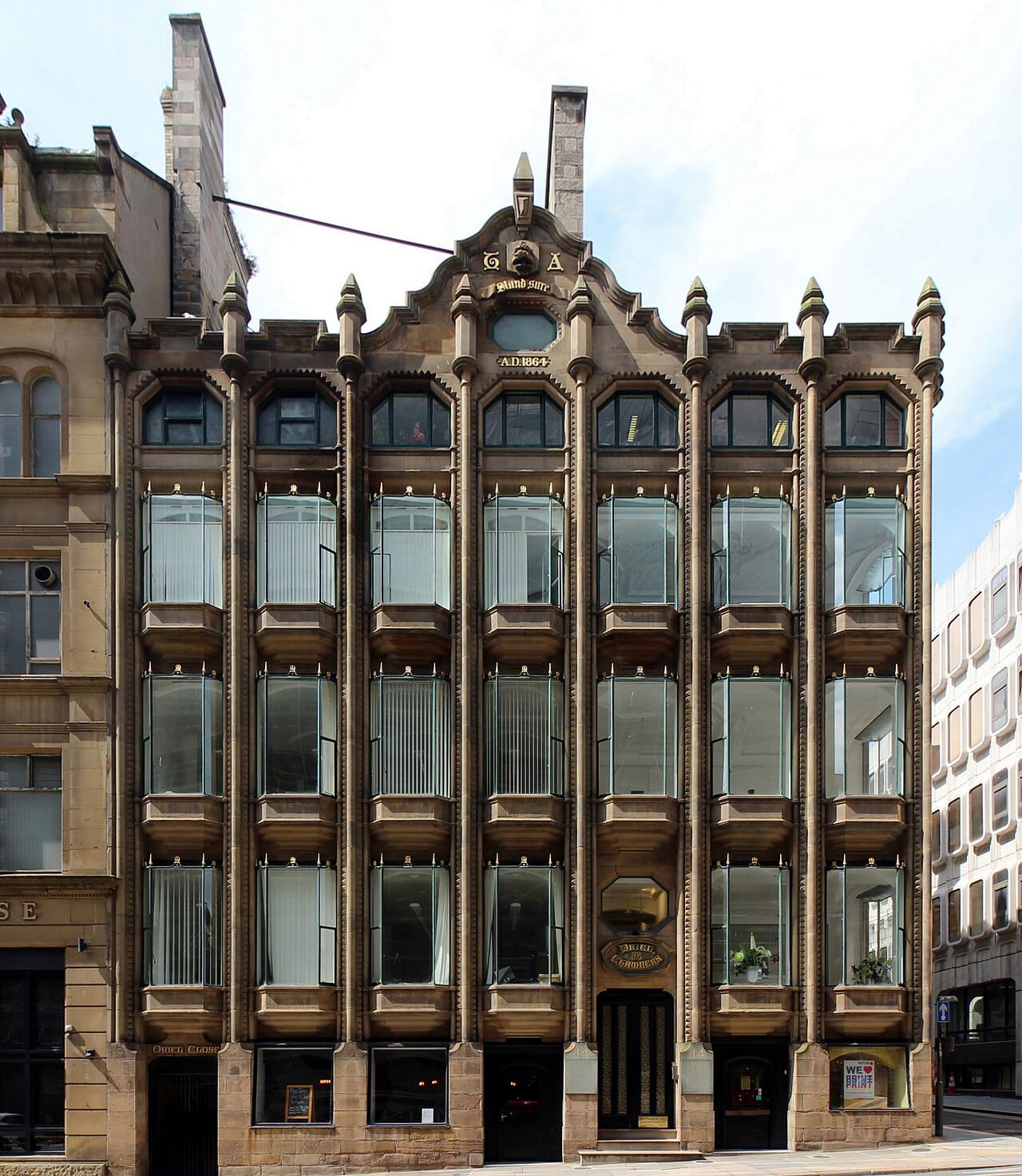 Oriel Chambers in Liverpool, completed in 1864, whose iron frame and large glazed bays anticipate later curtain wall construction.