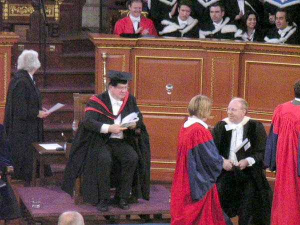 A degree ceremony. The academic dress, the conferral of degrees and the ceremonial structure are among the most direct medieval survivals in modern institutional life.
