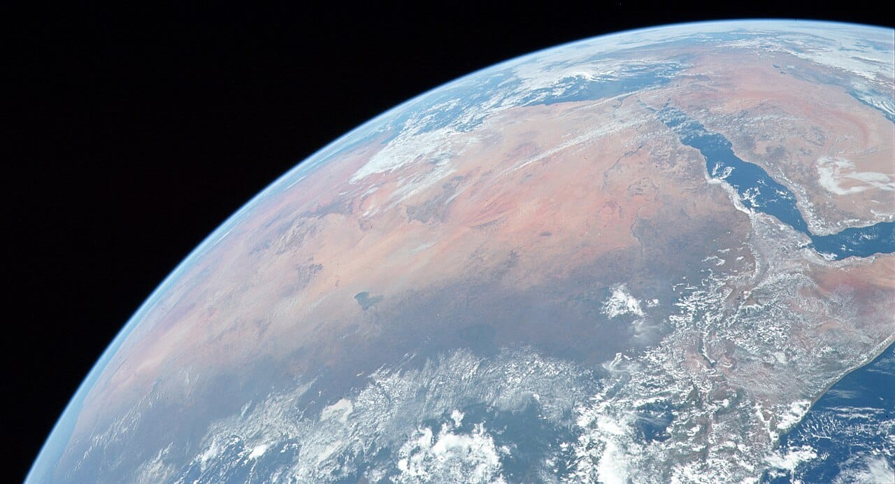 The Sahara from orbit. Tunisia's southern half lies within the great desert, which reaches the country through salt flats, dune fields, and oases, while the north remains fully Mediterranean in climate and vegetation.