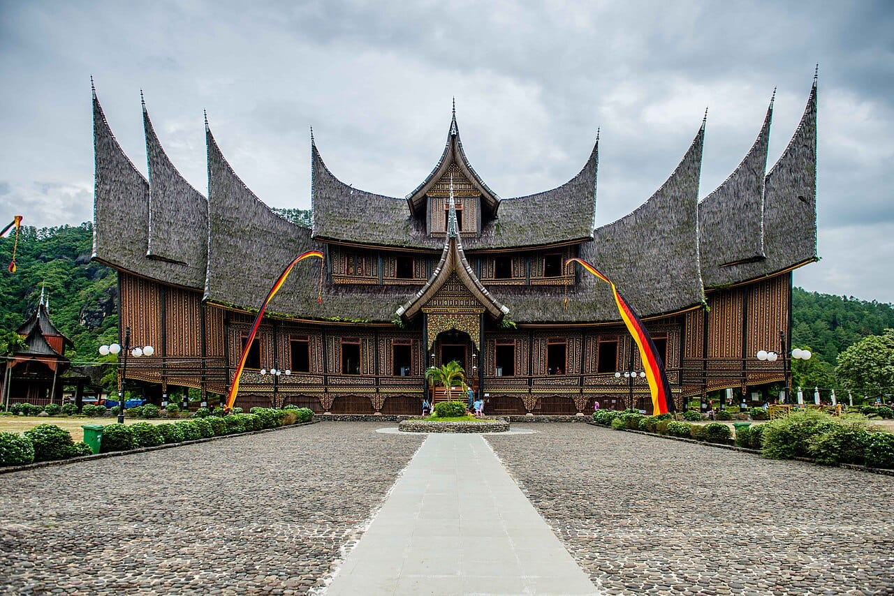 A Minangkabau house in Sumatra. Steep roofs shed heavy tropical rain, raised floors provide ventilation and protection from flooding and animals, and wide eaves shade the walls.