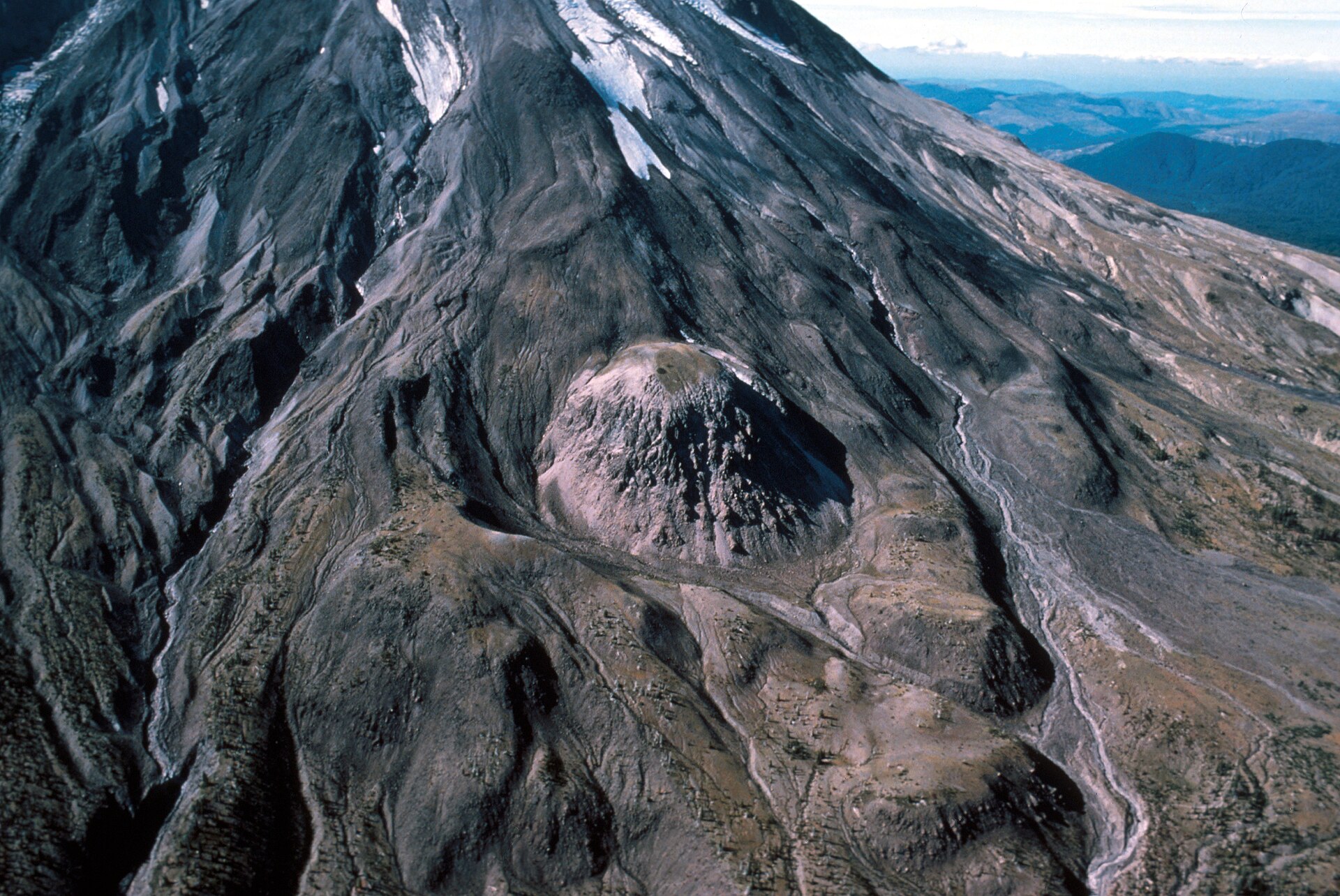 A lava dome on the flank of Mount St. Helens, built from thick, slow-moving lava. Credit: USGS / Rick Hoblitt (Public domain).