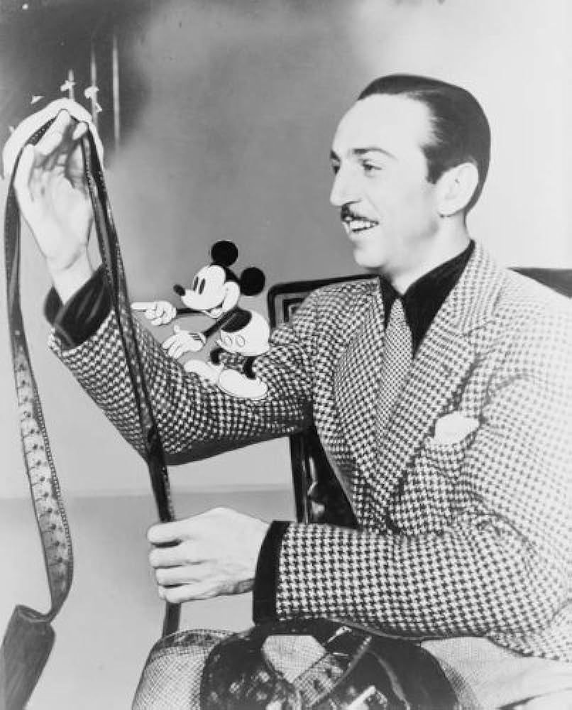 Disney with a reel of film and Mickey Mouse, the character that launched his empire, in 1935.