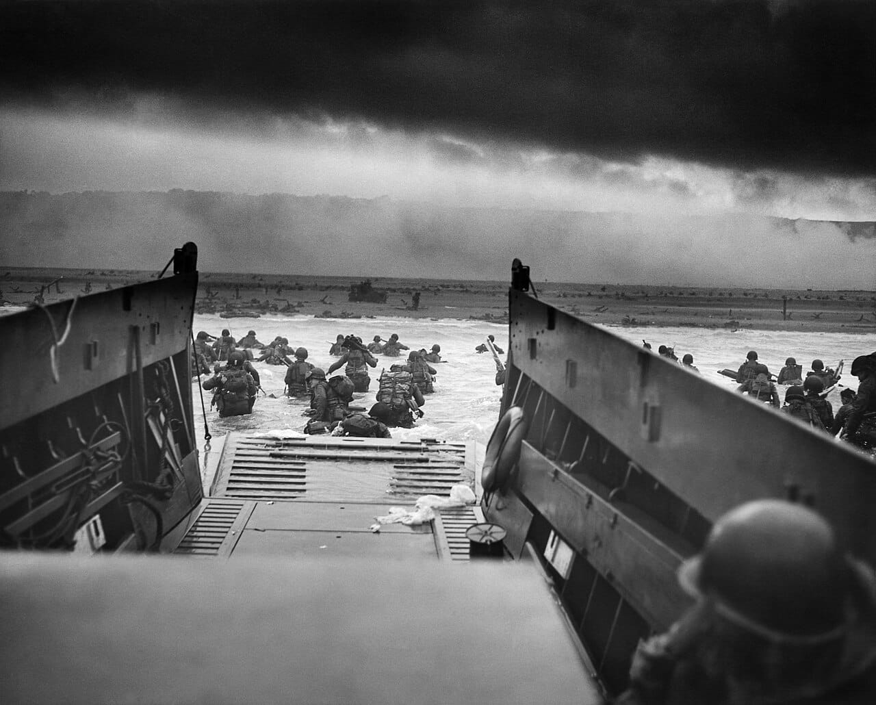 American troops wading ashore under fire at Normandy on D-Day, 6 June 1944, the largest seaborne invasion ever mounted.